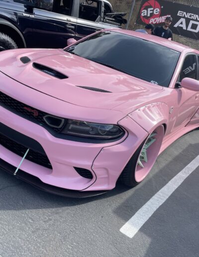 Front of pink Dodge SRT with aFe Power banner in background