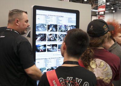 Man showing customers products on electronic kiosk at car show