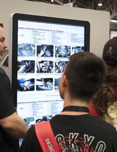 Man showing customers products on electronic kiosk at car show