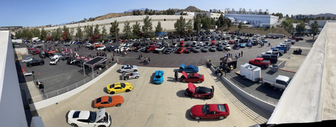 Aerial view of aFe POWER Cars and Coffee event at 1375 Sampson in Corona California with full parking lot of expensive and modified cars and car meet with lots of people walking around having fun 