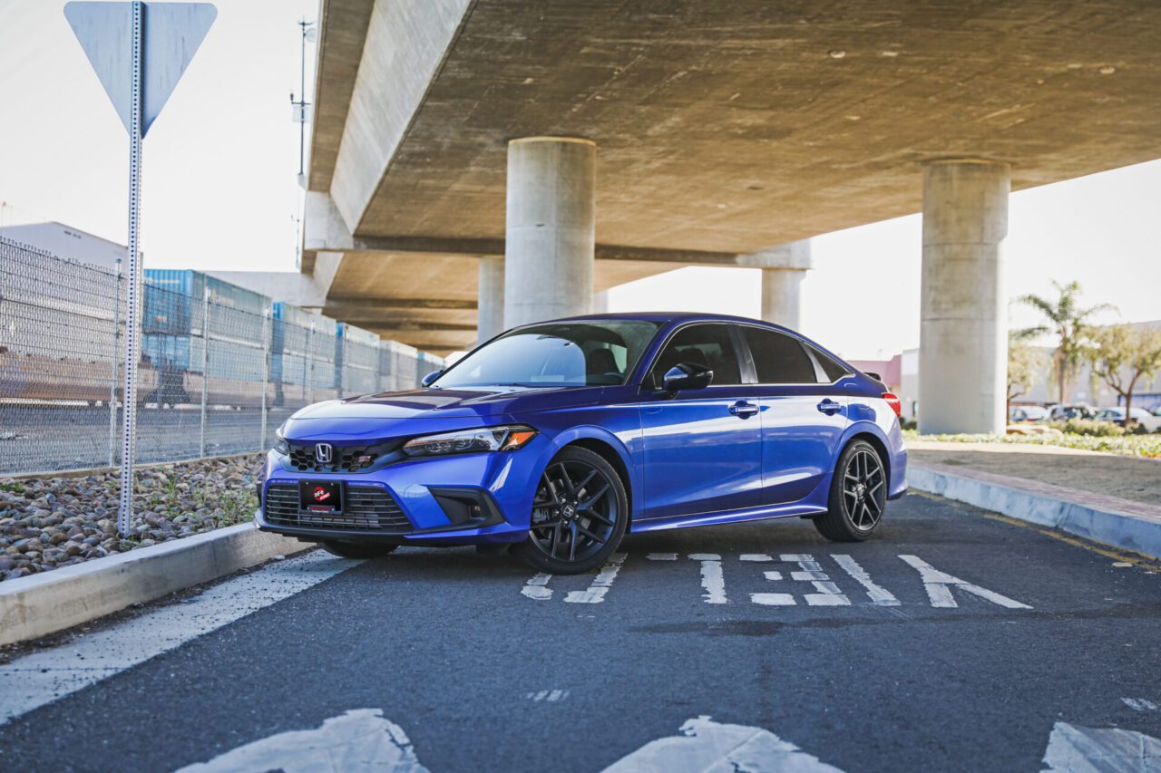 2022 Blue Honda Civic Si with AFE Takeda Mods on industrial street background under overpass