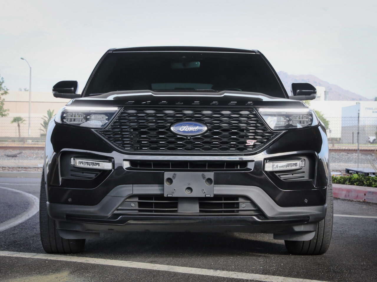 Front grille view of 2023 Black Ford Explorer ST with AFE aftermarket parts build on street background