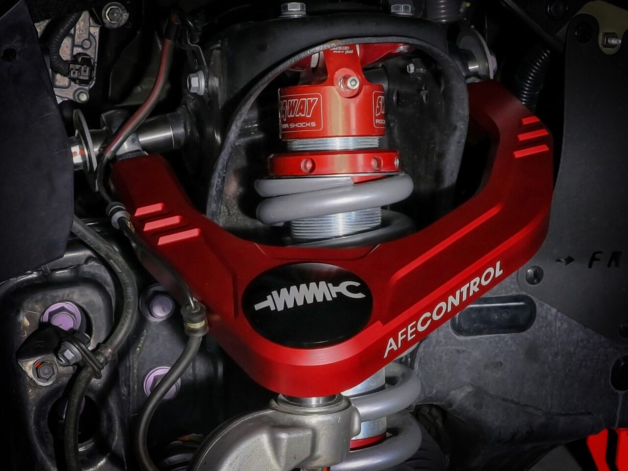 Red upper control arm around coilover Sway-a-way shock installed on Toyota Tundra