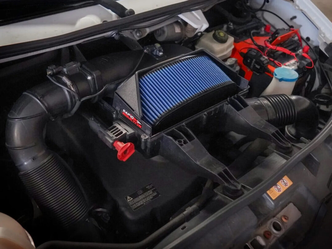 pen style aftermarket cold air intake with big blue oiled filter using half of factory airbox on Mercedez-Benz 2500/3500 2.1L turbodiesel engine under hood