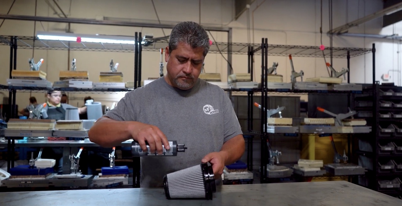 Man oiling AFE Filter in warehouse with blue oil