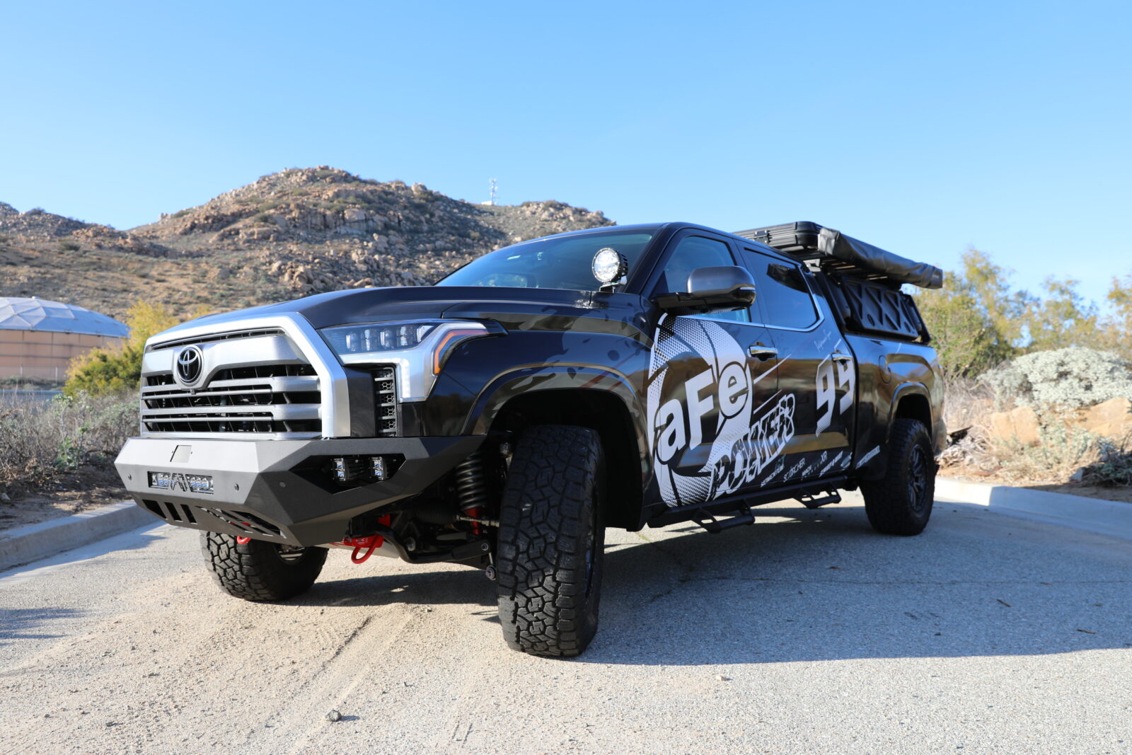 Gear-equipped lifted Grey Gen 3 Tundra off-roading with aFe POWER parts and logo