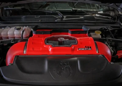 AFE Momentum Red Sealed Cold Air Intake installed in RAM TRX showing dinosaur easter egg in engine bay