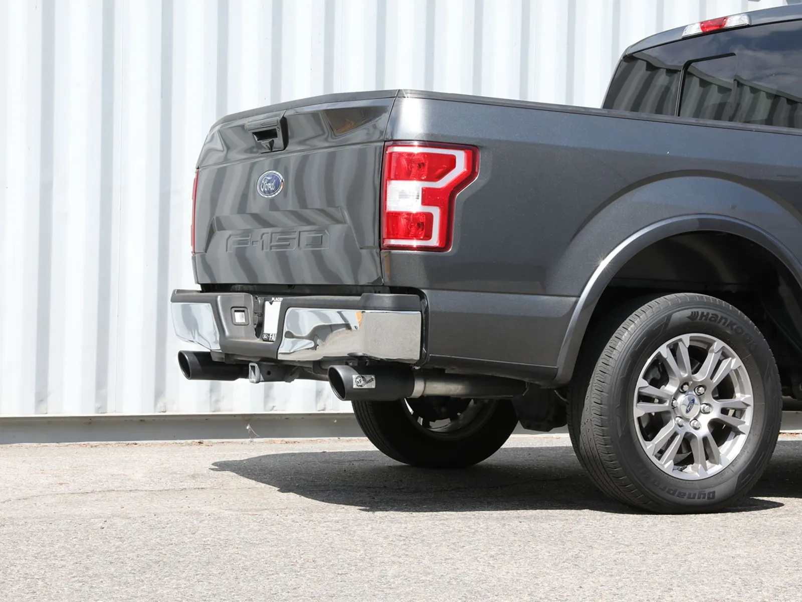 Rear of 15-20 F-150 with large aFe Exhaust System tips in industrial background