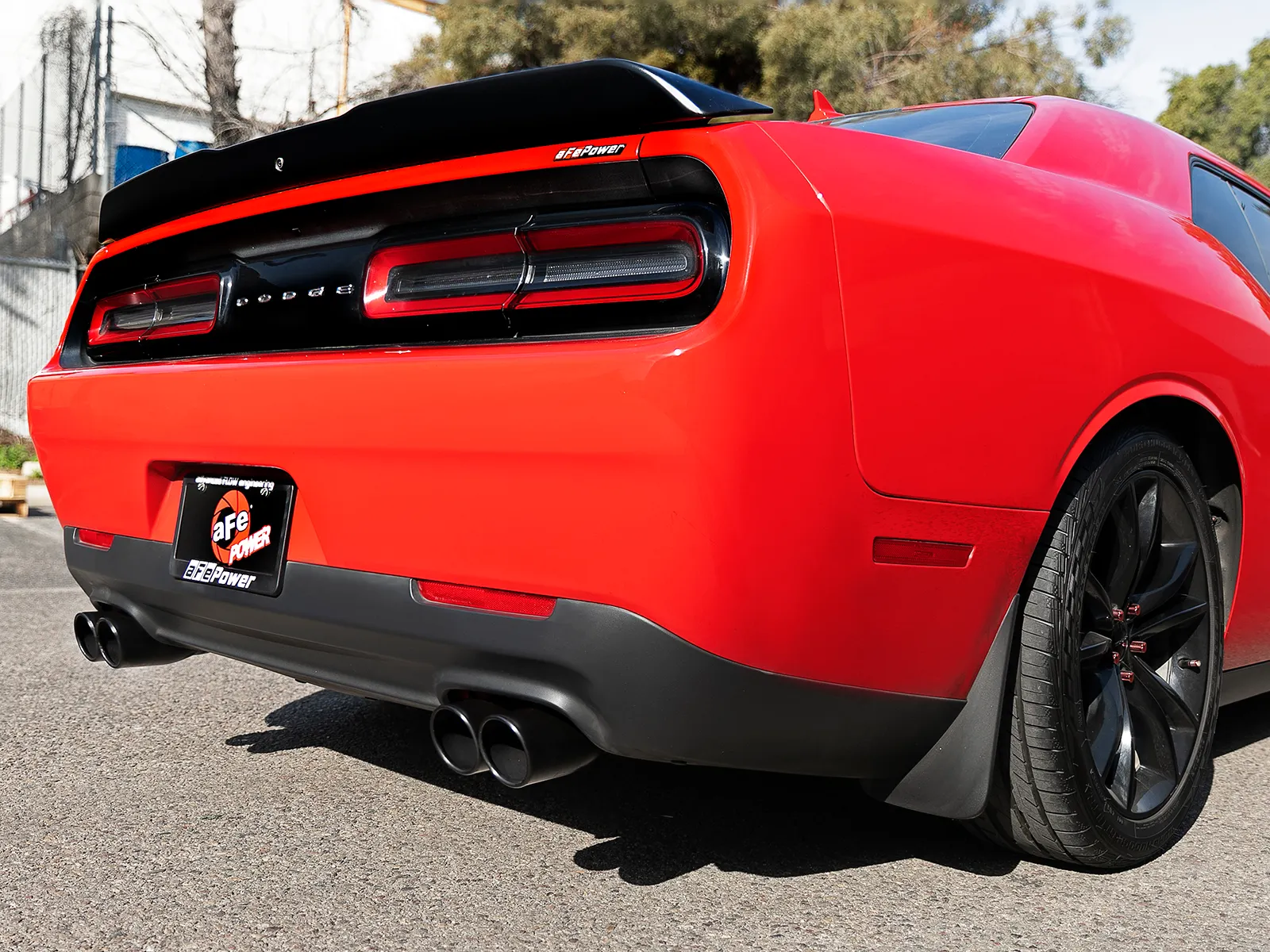 Rear angle shot of Red Dodge Challenger V6 3.6L with aFe exhaust system's quad exhaust itps