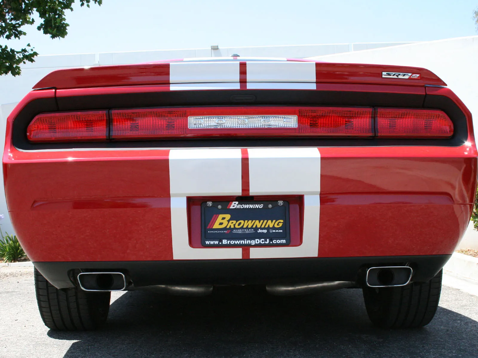 Rear of Red Dodge Challenger SRT 8 white white stripe and Browning license plate with dual aFe POWER rectangular exhaust tips