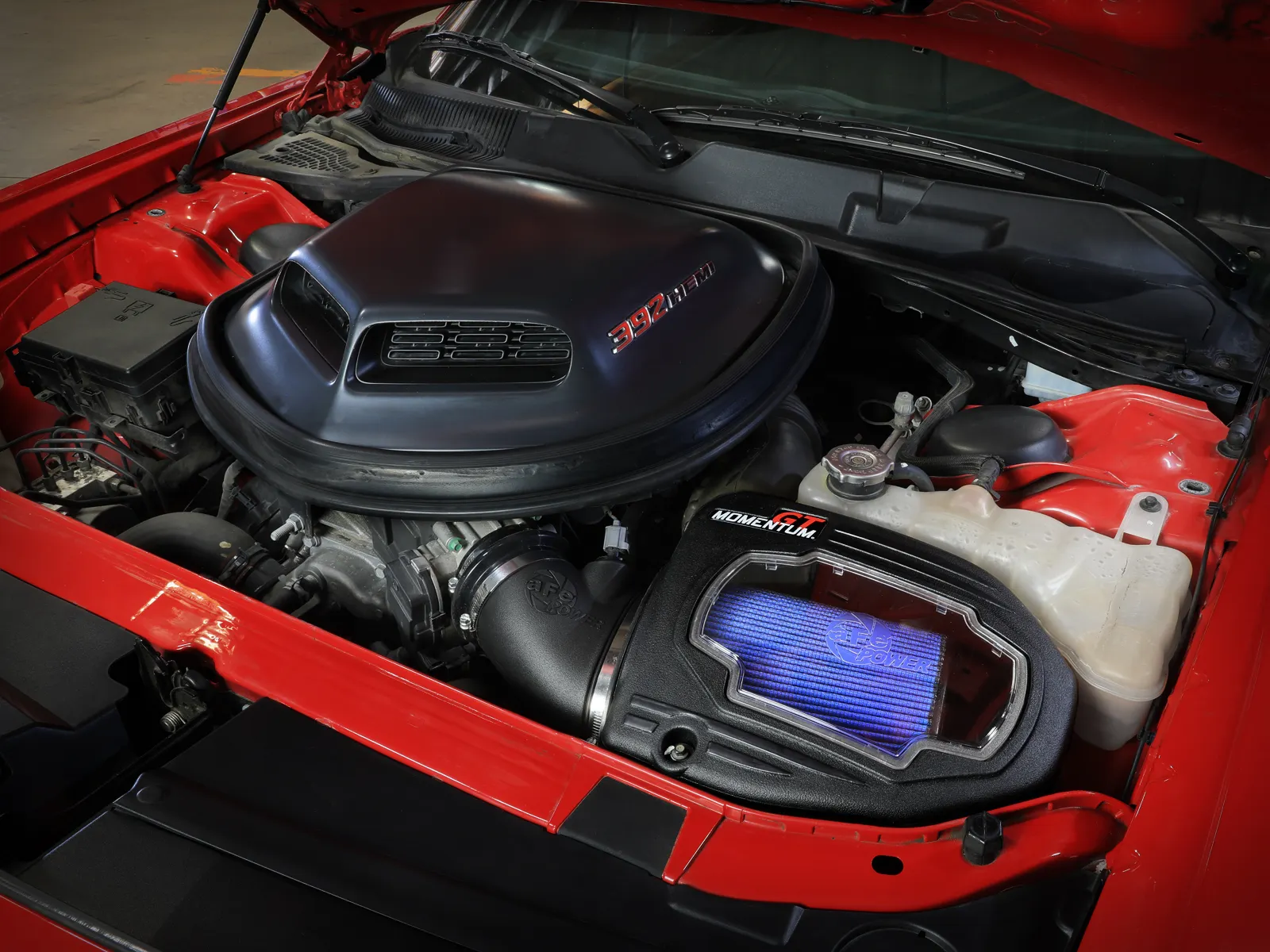 aFe Cold Air Intake with big window to blue air filter installed on red Dodge Challenger with shaker hood